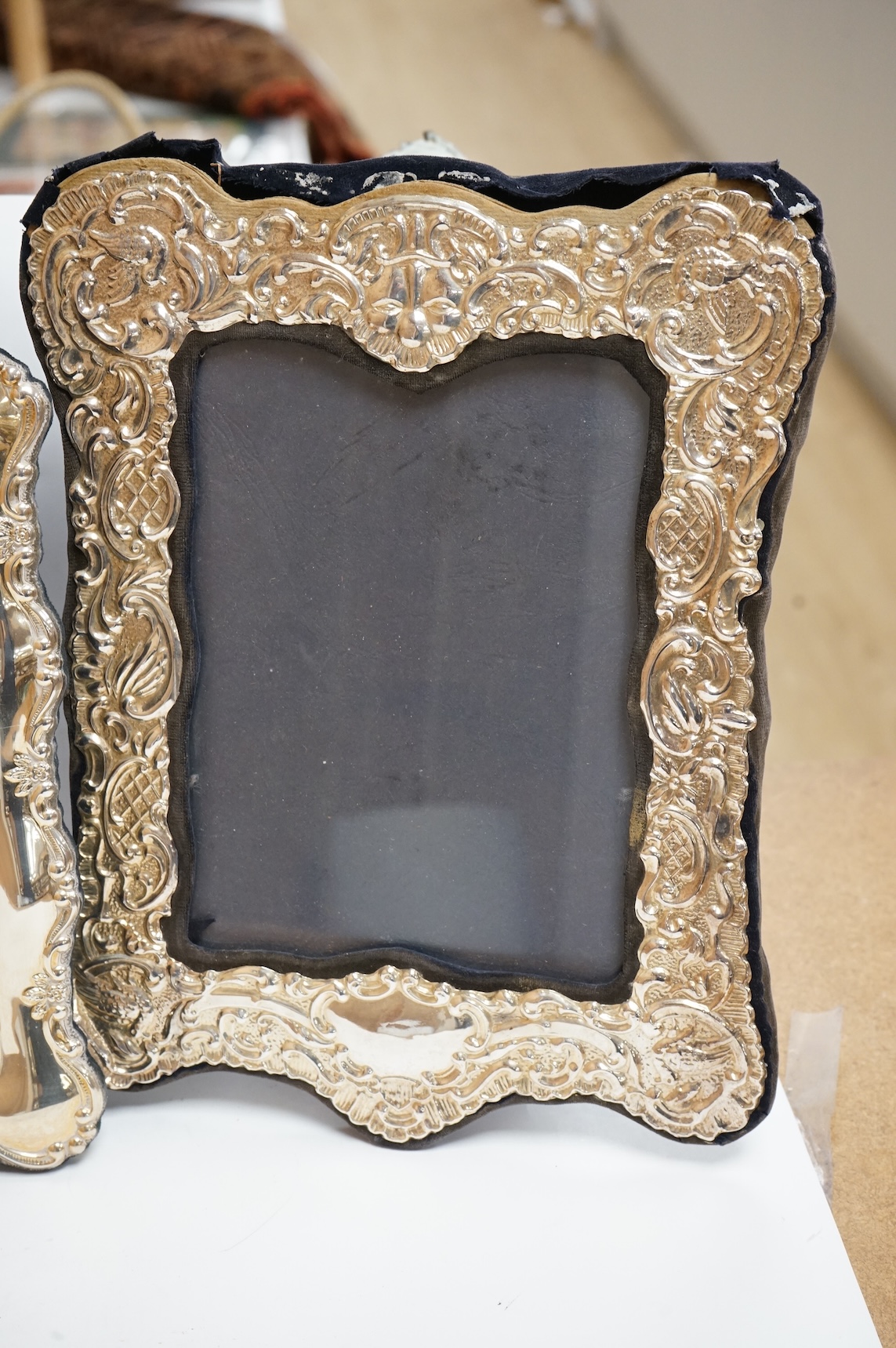 A George V silver mounted rectangular photograph frame, with ribbon bow crest, by Stokes & Ireland Ltd, Chester, 1912, 18.2cm including crest, together with ten other modern silver mounted photograph frames, largest 29.4